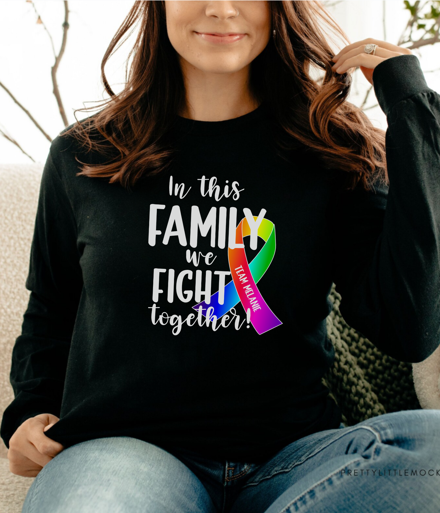 a woman sitting on a couch wearing a black shirt that says, in this family