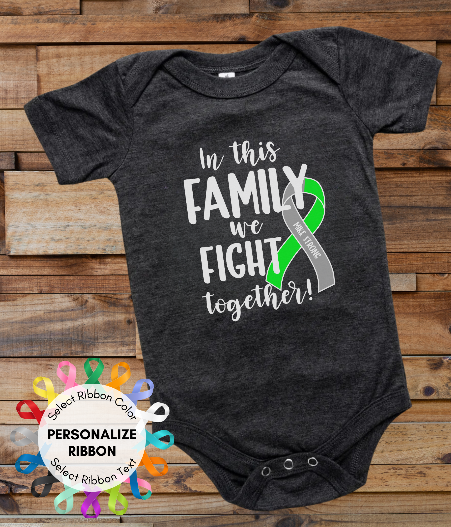 a black onesuit with a green and white ribbon that says in this family we