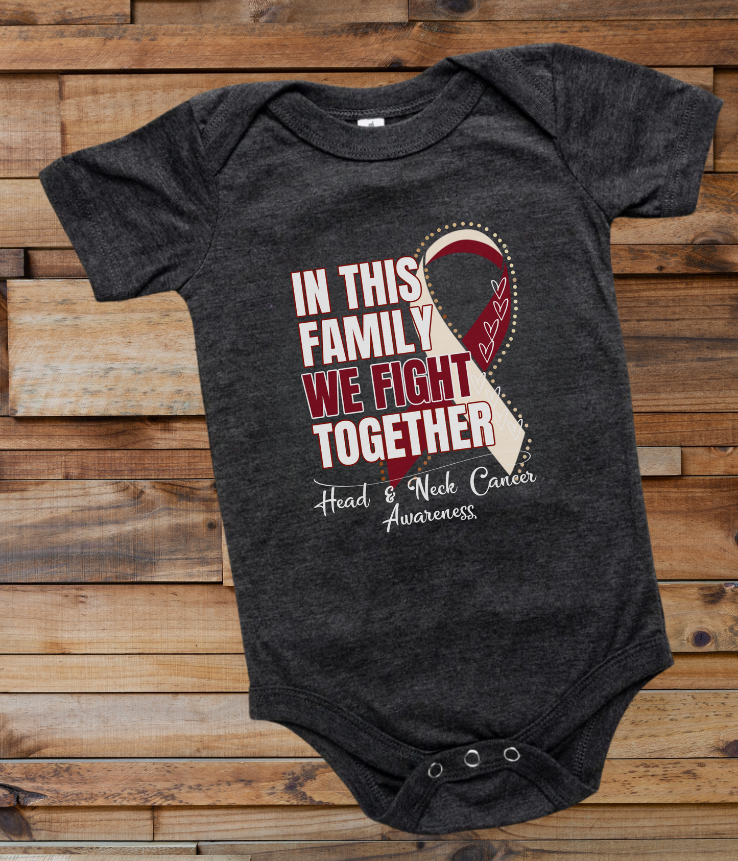 a black onesuit with a red and white ribbon in this family we fight together