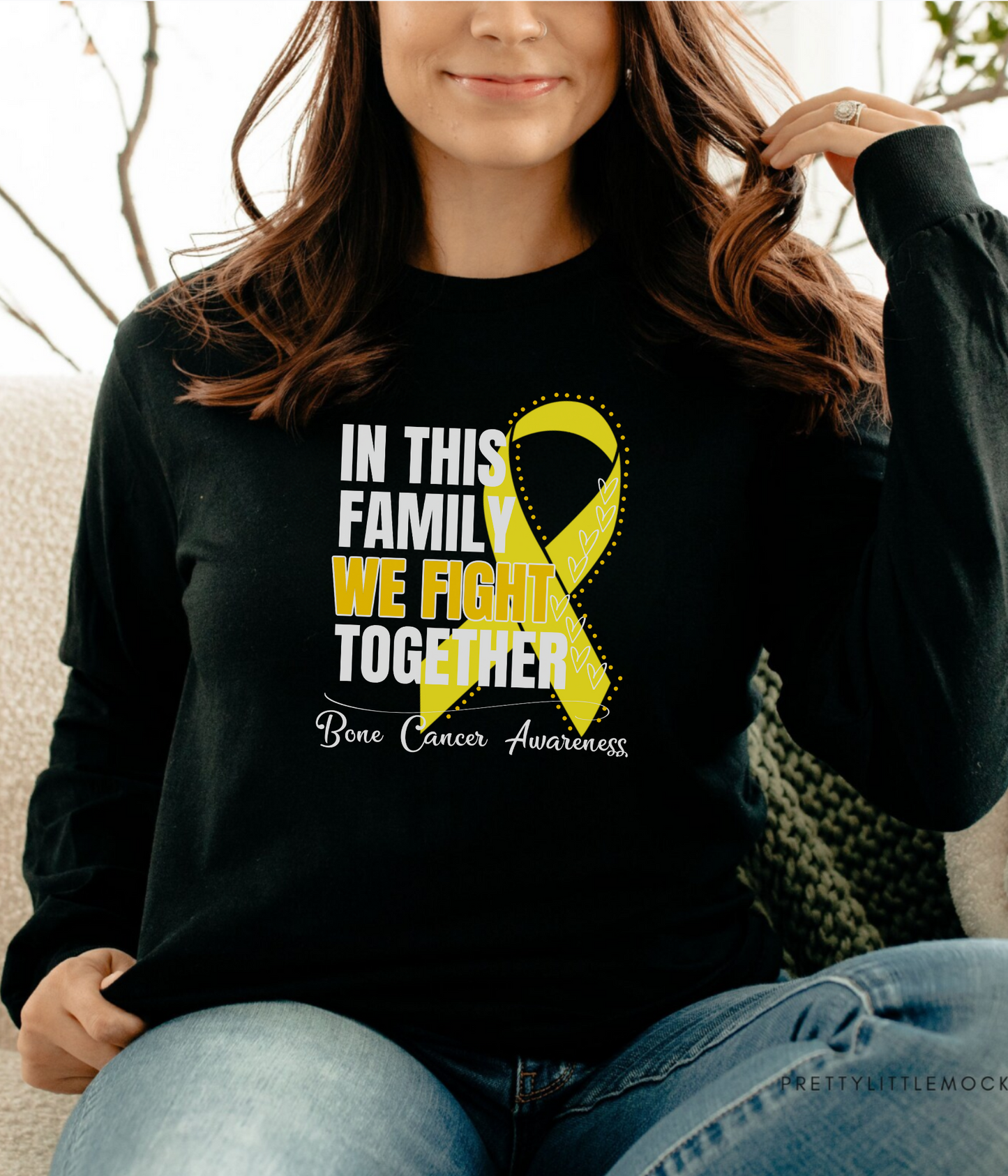 a woman sitting on a couch wearing a t - shirt that says in this family