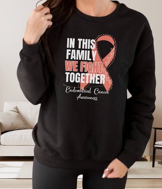 a woman wearing a black sweatshirt with a pink ribbon on it