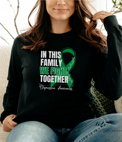 a woman sitting on a couch wearing a black shirt with a green ribbon