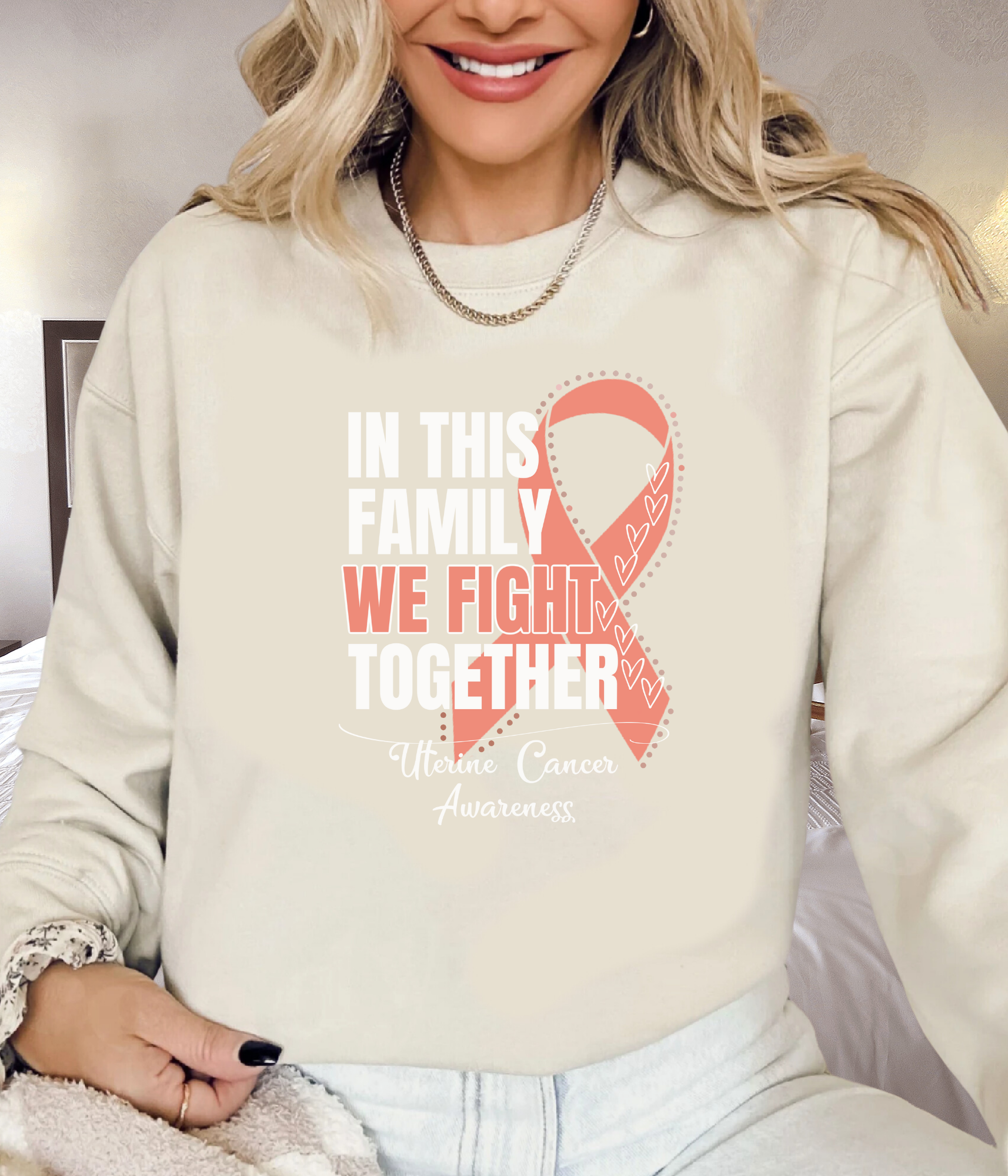 a woman wearing a sweatshirt with a pink ribbon on it