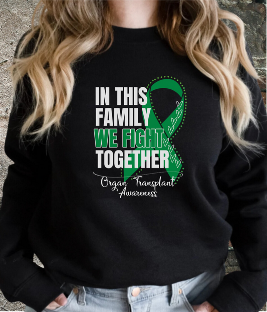 a woman wearing a black sweatshirt with a green ribbon on it