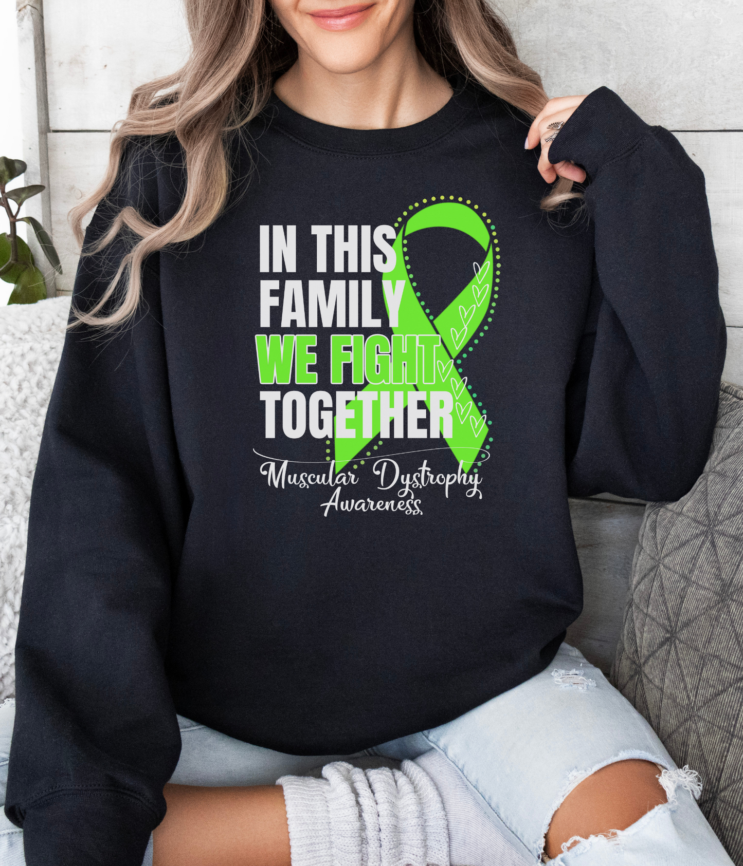 a woman wearing a black sweatshirt with a green ribbon on it