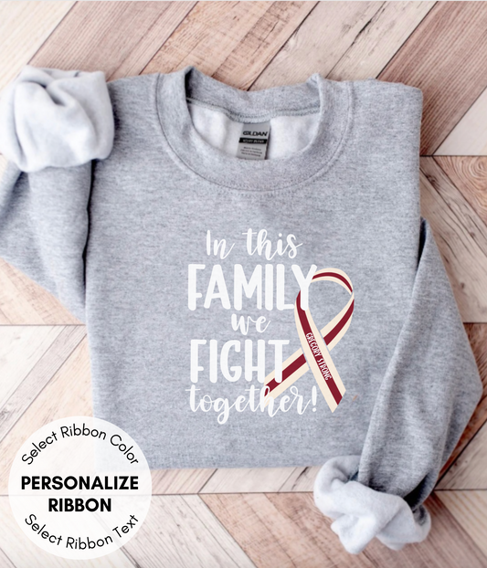 a gray shirt with a red ribbon on it that says in this family we fight