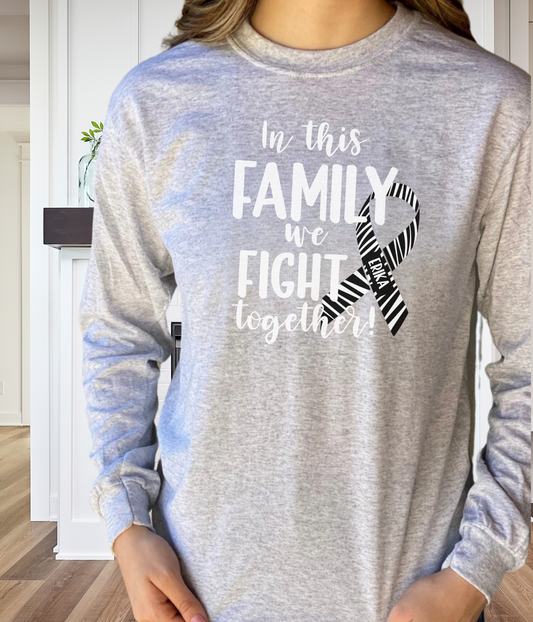 a woman wearing a grey shirt that says in this family we fight together