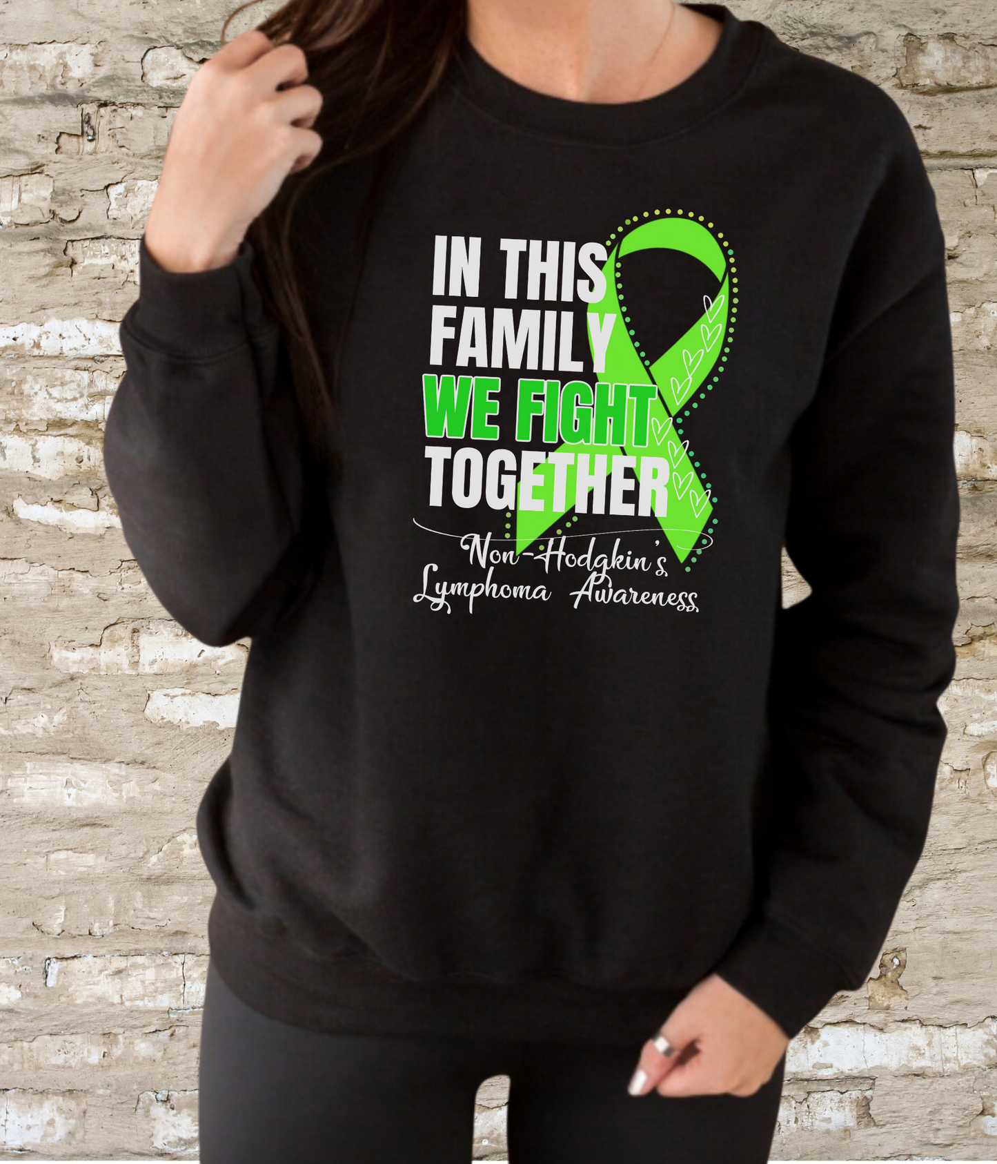 a woman wearing a black sweatshirt with a green ribbon on it