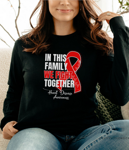 a woman sitting on a couch wearing a black shirt with a red ribbon on it