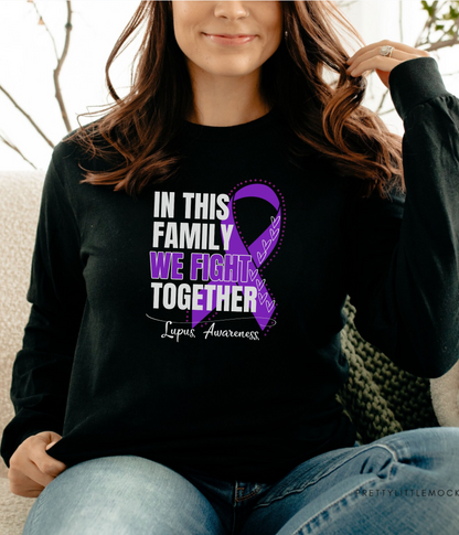 a woman sitting on a couch wearing a black shirt with a purple ribbon