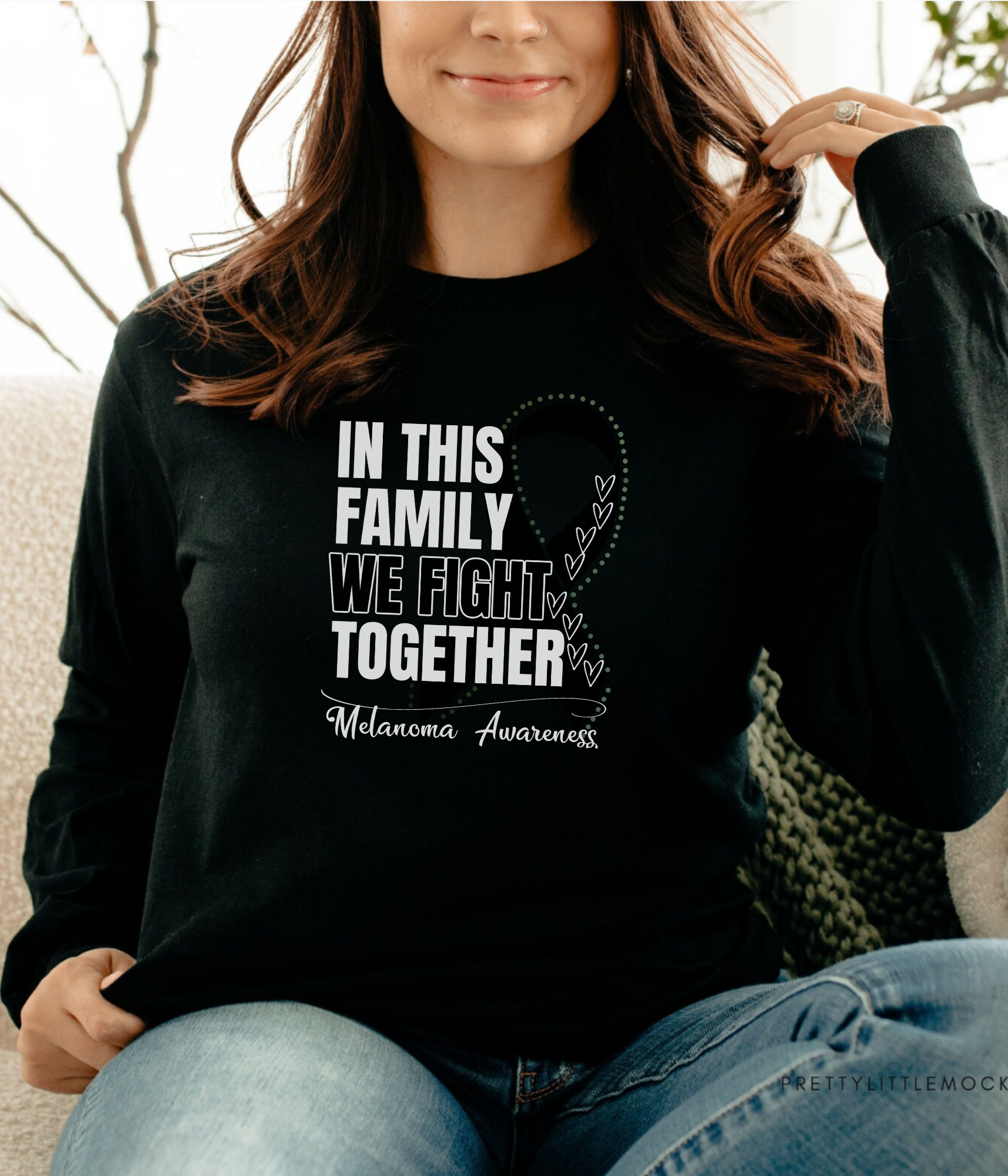 a woman sitting on a couch wearing a black shirt