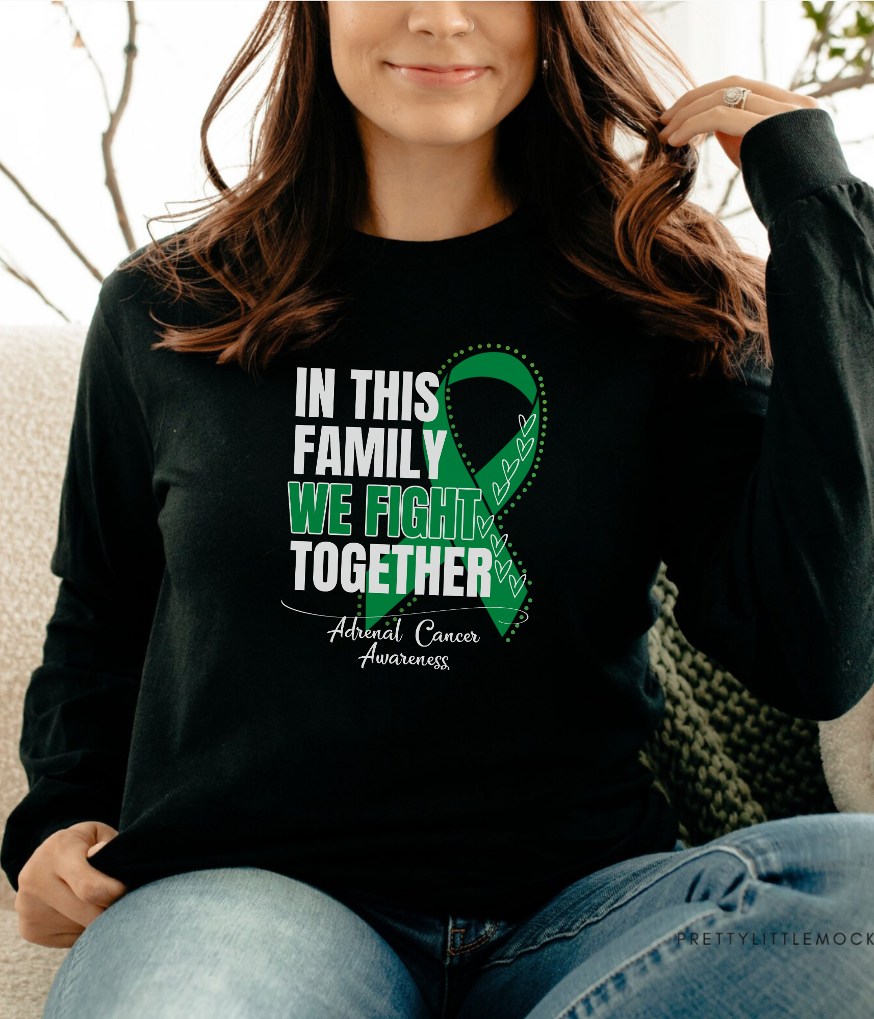 a woman sitting on a couch wearing a black shirt with a green ribbon