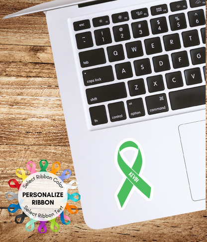 a laptop computer with a green ribbon sticker on it