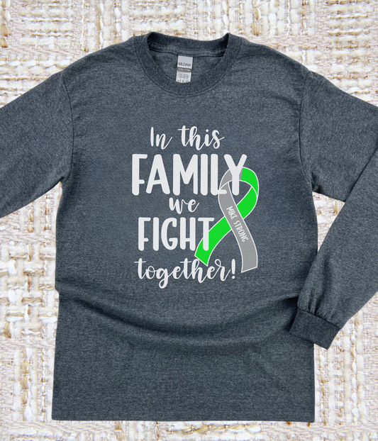 a gray shirt with a green ribbon on it that says in this family we fight
