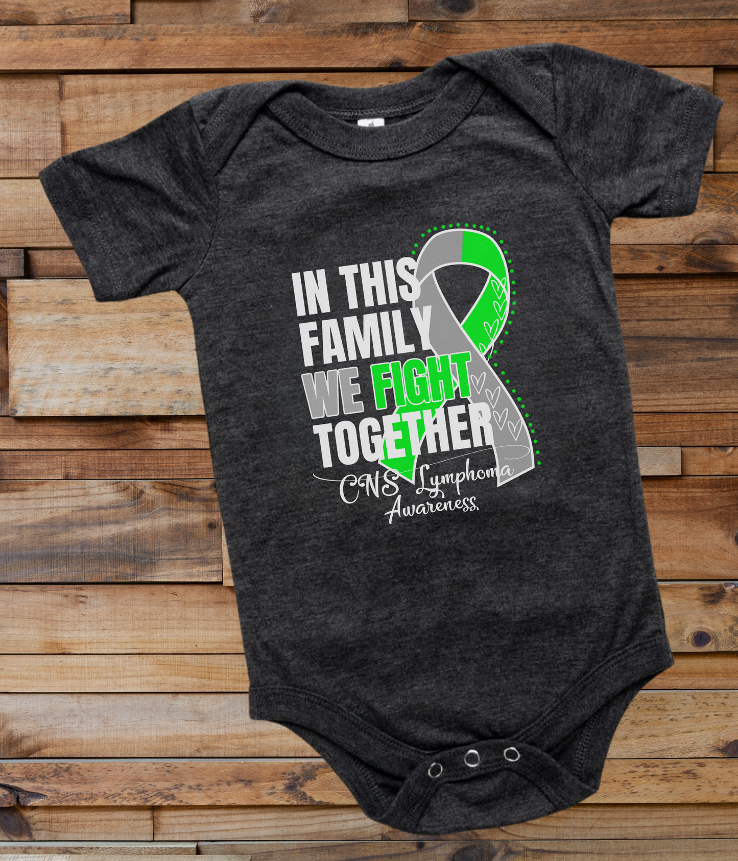 a black onesuit with a green ribbon on it that says in this family we