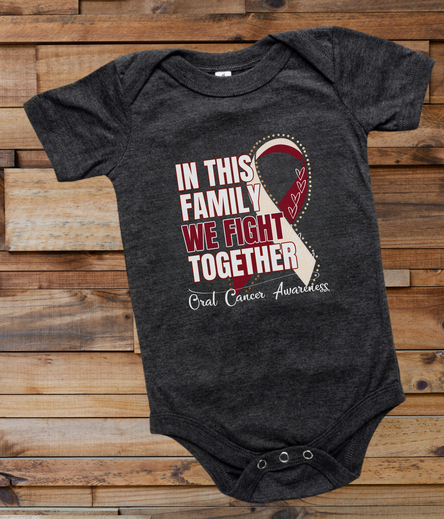 a black onesuit with a red and white ribbon in this family we fight together