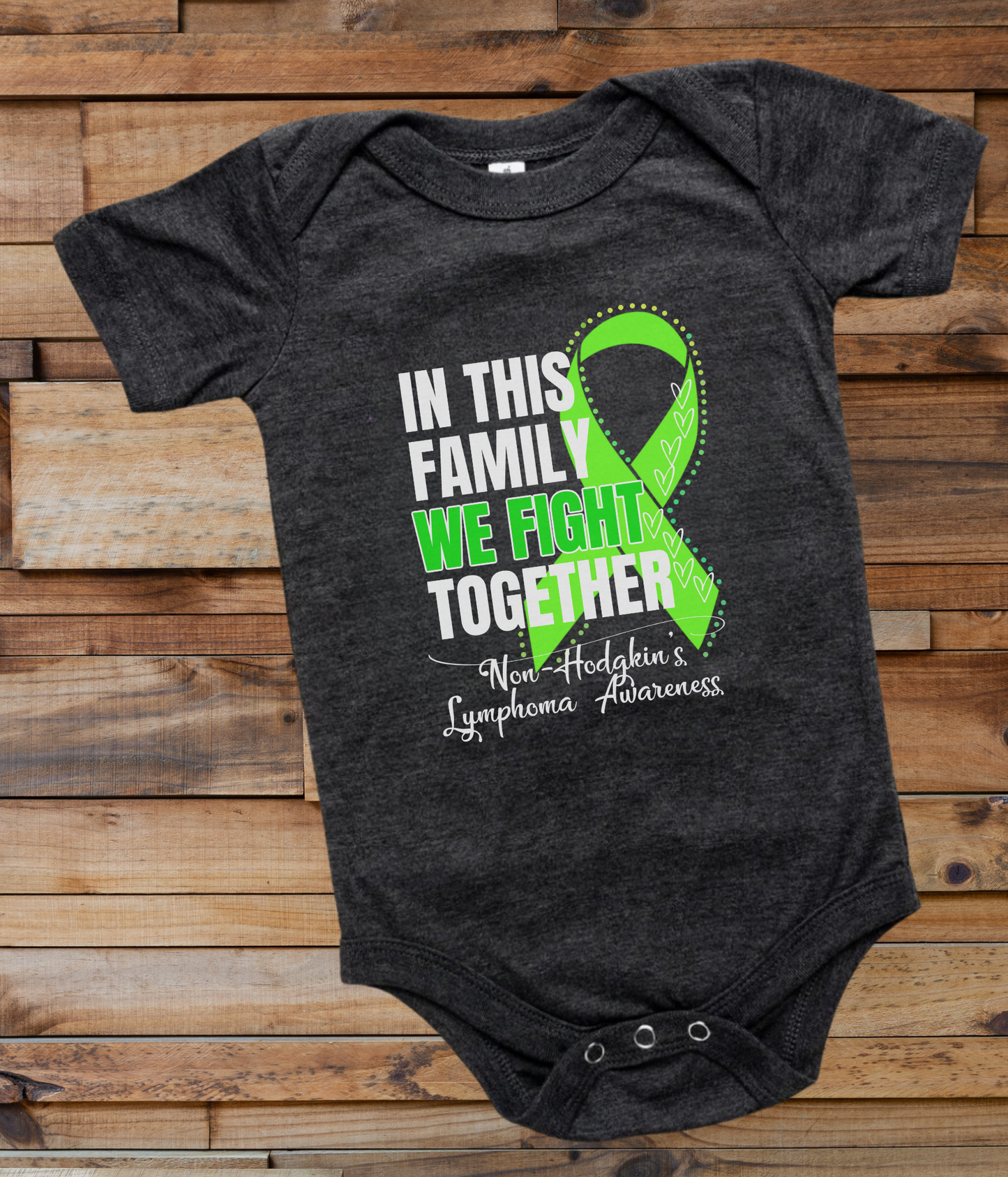 a black onesuit with a green ribbon in this family we fight together